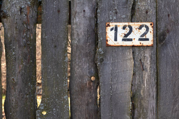 istock Wooden old fence with number 122 on a rusty plate 1208760600