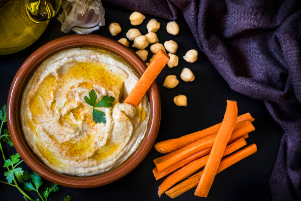 hummus fait maison avec des bâtonnets de carotte - houmous photos et images de collection