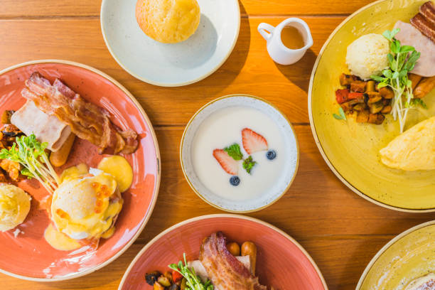 istock Fried egg with eggs benedict and omelette around bacaon ham sausage in plate 1208761943