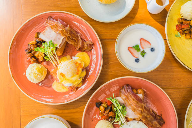 istock Fried egg with eggs benedict and omelette around bacaon ham sausage in plate 1208761985