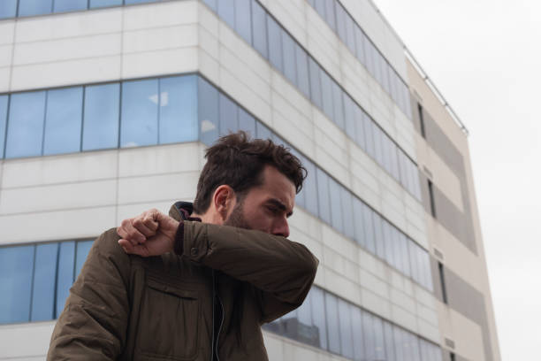 hombre tosiendo en la ciudad - cough remedy fotografías e imágenes de stock