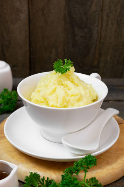 istock Mashed potatoes in white bowl or glass with parsley on wooden table. 1208762864