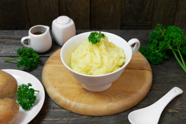 istock Mashed potatoes in white bowl or glass with parsley on wooden table. 1208762898