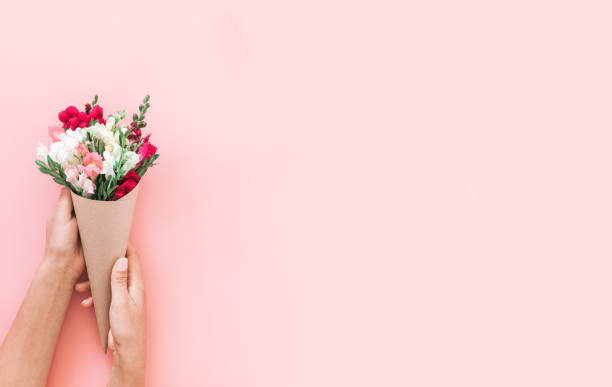 istock Roses bouquet in cone on pink background, flat lay, top view. 1208762989