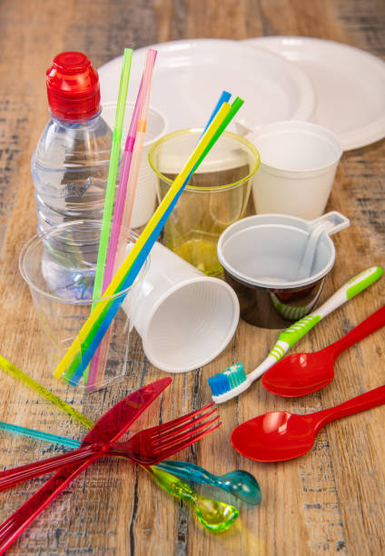 istock Everyday plastic waste, various plastic utensils, environmental protection on wood background 1208763515