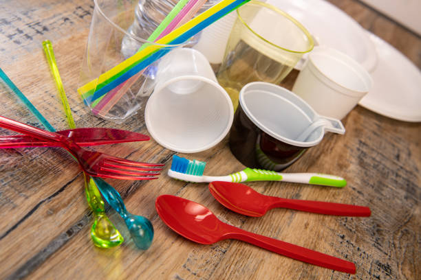 istock Everyday plastic waste, various plastic utensils, environmental protection on wood background 1208764580
