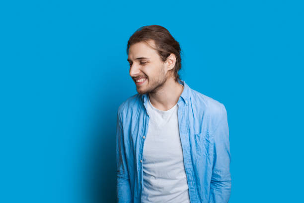istock Smiling caucasian boy having fun after finding out some good news while posing on a blue wall 1208766187