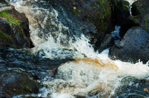 istock foamy stream on black stones, long exposure 1208766724