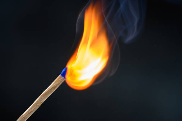 istock Wooden match stick with blue head ignited 1208767340