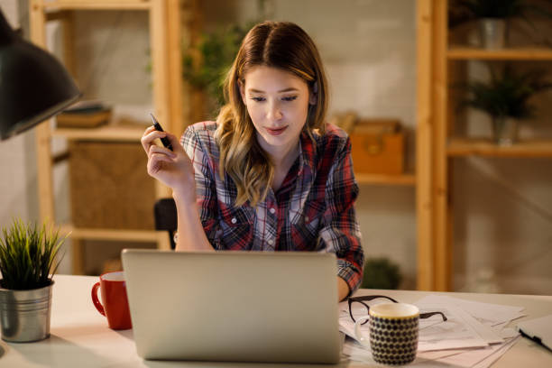 istock Young woman doing finances at home using laptop 1208768321