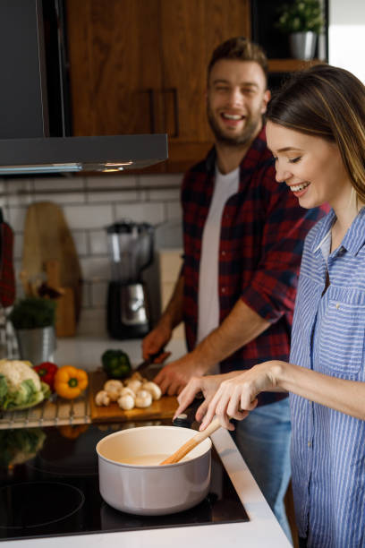 istock Young romantic couple cooking in the kitchen together 1208769683