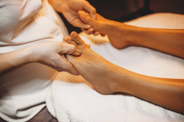 istock Young caucasian physiotherapist is massaging patient's legs during a spa procedure 1208770695