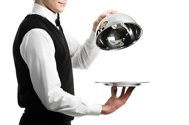 Close up hands of waiter with metal cloche lid cover
