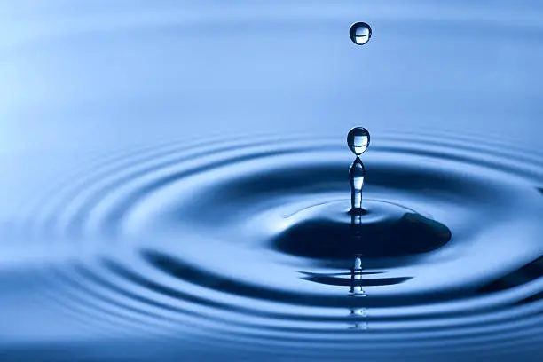 Photo of Close-up shot of water drop in dark blue shade