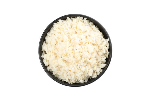 istock Boiled rice in black bowl isolated on white background 1208775738