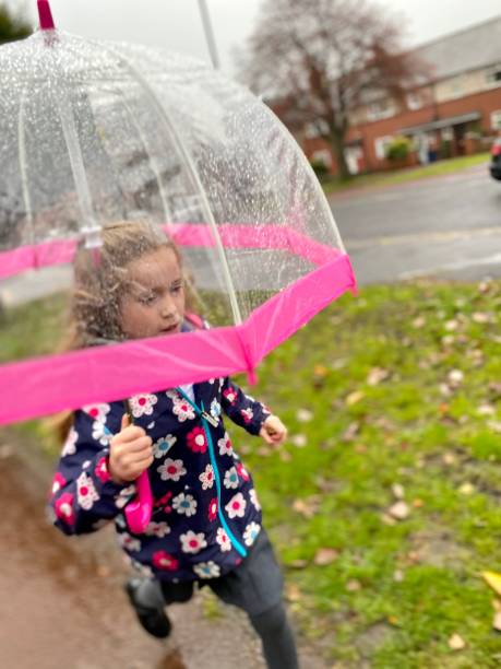 6-jähriges Mädchen läuft im Regen zur Schule – Foto