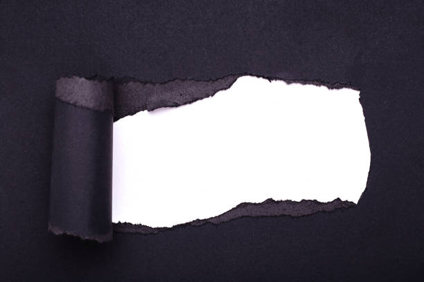 istock Hole in the black paper. Torn. White paper background. Abstract background. 1208780439