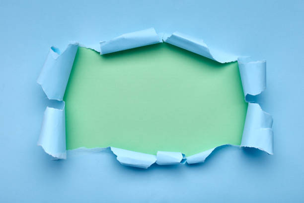 istock Hole in the blue paper. Torn. Green background. Abstract background. 1208780531