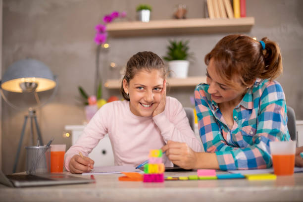 istock Mother helping daughter with homework. 1208780620