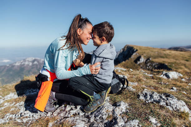 istock Cheerful mother and child relaxing on a mountain top 1208781052