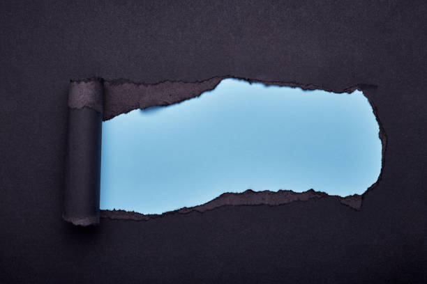 istock Hole in the black paper. Torn. Wooden background. Abstract background. 1208782347