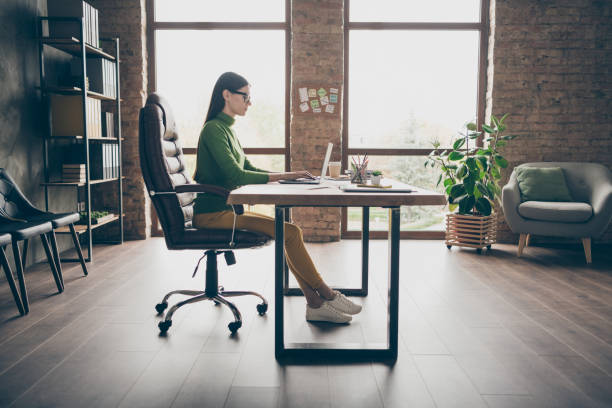 Full length profile photo of busy brunette business lady resourceful person notebook table modern user sit boss chair wear specs green turtleneck yellow pants modern interior office Full length profile photo of busy brunette business lady resourceful person, notebook table modern user sit boss chair wear specs green turtleneck yellow pants modern interior office office chair stock pictures, royalty-free photos & images