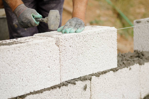 istock Close-up of construction worker builds brick wall 1208785167