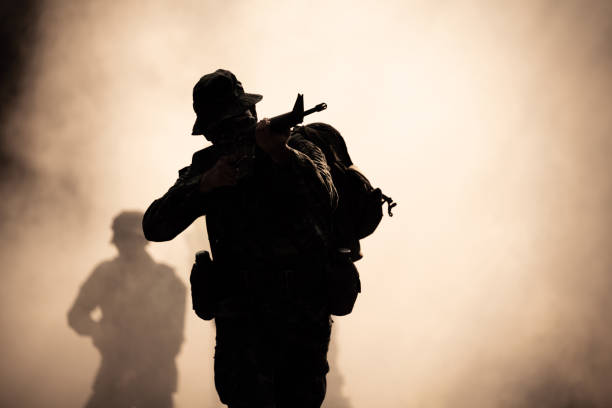 silhouette action soldiers walking hold weapons in jungle