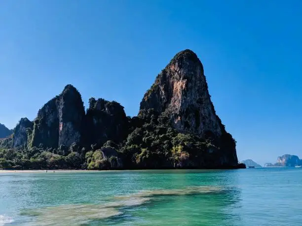 Aonang, Krabi / Thailand - February 11, 2019: Aonang Beach, the beautiful and famous place in Thailand. Blue sky cloudy, mountain and green sea with long tail boats, good for the vacation season.