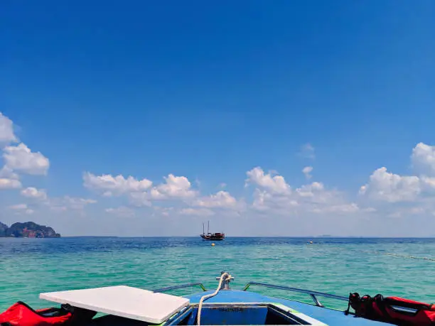 Aonang, Krabi / Thailand - February 11, 2019: Aonang Beach, the beautiful and famous place in Thailand, blue sky cloudy and green sea with the front of speed boat, good for the vacation season.