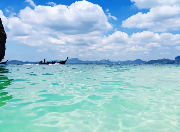 Aonang, Krabi / Thailand - February 11, 2019: Aonang Beach, the beautiful and famous place in Thailand. Blue sky cloudy, mountain and green sea with long tail boats, good for the vacation season.