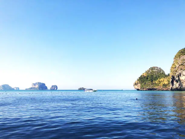 Aonang, Krabi / Thailand - February 11, 2019: Aonang Beach, the beautiful and famous place in Thailand. Blue sky cloudy, mountain and green sea with speed boat, good for the vacation season.