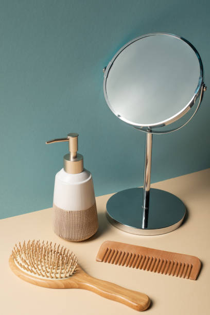 istock Comb, hair brush, liquid soap dispenser and mirror on beige and grey, zero waste concept 1208793454