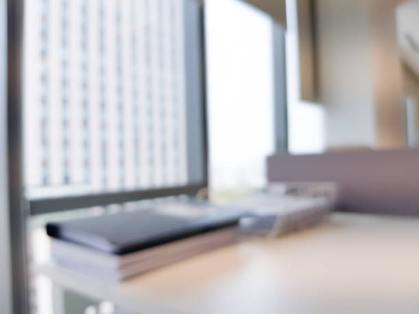 istock Blurred interior of modern office workplace a workspace design high rise glass window building decorate with document, black, white and wooden furniture. Nice environment can create work productivity. 1208796834