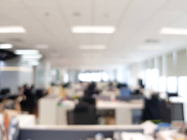 istock Blurred interior of modern office workplace a workspace design without partition decorate with black, white and wooden furniture. Nice environment can create work productivity, relax mood. 1208796849