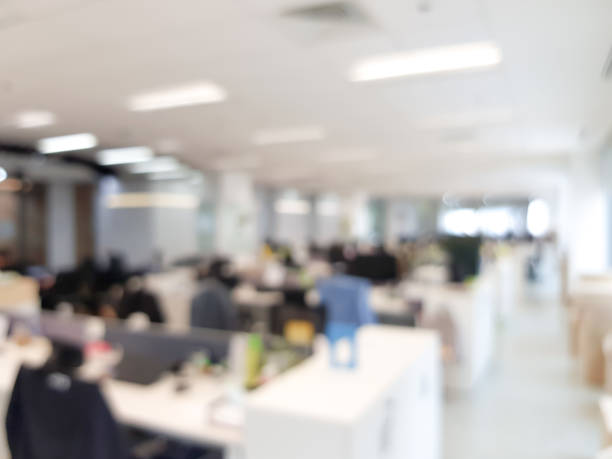 istock Blurred interior of modern office workplace a workspace design without partition decorate with black, white and wooden furniture. Nice environment can create work productivity, relax mood. 1208796857
