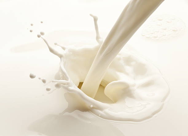 Splash of milk Splash of milk on a white background pouring stock pictures, royalty-free photos & images