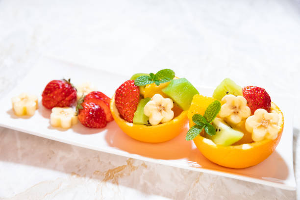 The bowl is made of orange and filled with different fruits