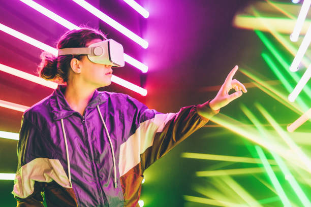 istock Girl using VR goggles in colorful neon lights studio. 1208799921