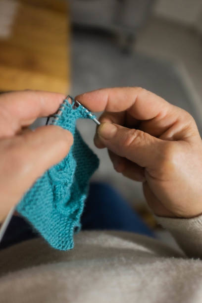 istock Woman knitting scarf 1208802632