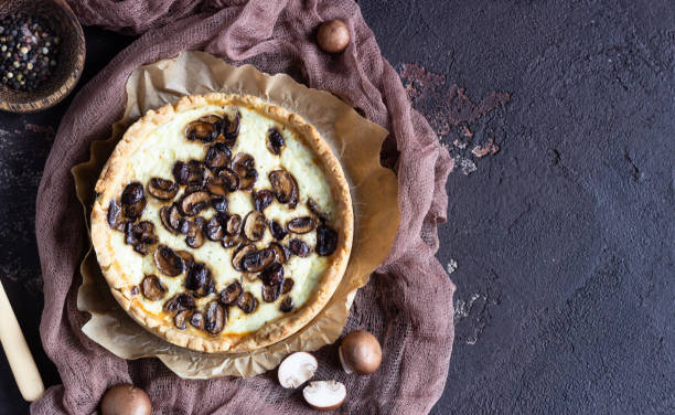 istock Quiche with champignons and cheese on dark brown concrete background. Savory tart with mushrooms. Copy space. 1208806465