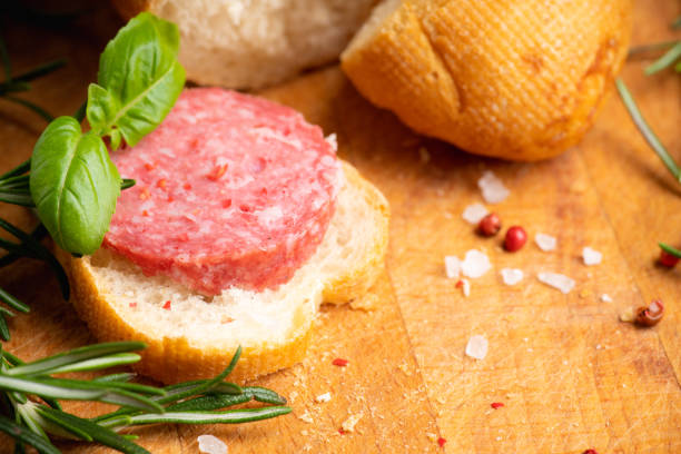 istock Bread with salami on the wooden background 1208807010