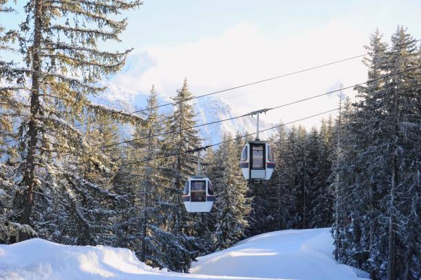 Ski lift in ski resort by winter Winter view of ski lifts with pine trees in background in ski resort Courchevel courchevel stock pictures, royalty-free photos & images