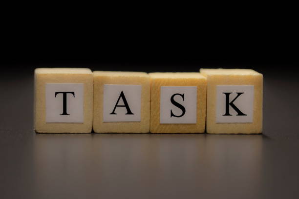 istock The word TASK written on wooden cubes isolated on a black background 1208807840