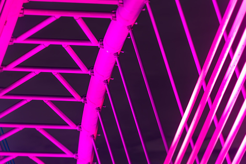 The illuminated structure of the Seri Saujana Bridge at night. One of many bridges in Putrajaya, Malaysia, all alternately illuminated in unison in different colors. Putrajaya Bridge Malaysia at night