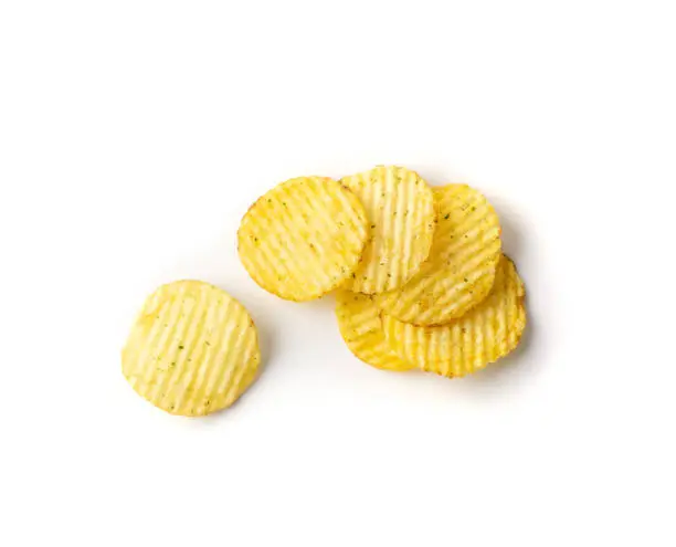Corrugated chips isolated on white background, wavy potato chips, crispy snack close up. Fluted crisps top view