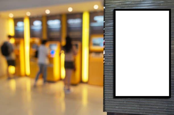 istock blank showcase billboard or advertising light box for your text message or media content with blurred view of people queuing to withdraw money from ATM, commercial, marketing and financial concept 1208816831