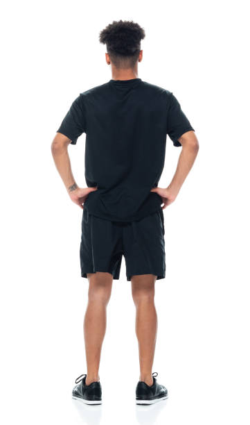 African-american ethnicity young male standing in front of white background wearing shorts Full length of aged 18-19 years old with curly hair african-american ethnicity young male standing in front of white background wearing shorts with hand on hip ass boy stock pictures, royalty-free photos & images