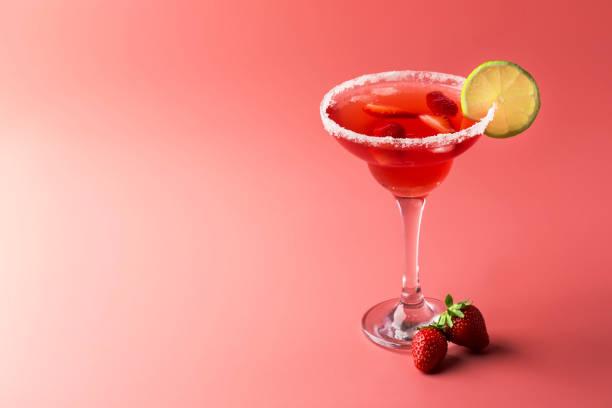 cóctel alcohólico margarita de fresa con tequila, licor, bayas, jugo de lima, azúcar y hielo, fondo rosado, espacio de copia - daiquiri fotografías e imágenes de stock