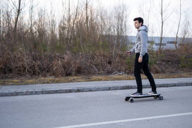 istock Man on a electric skateboard on an empty road 1208822624